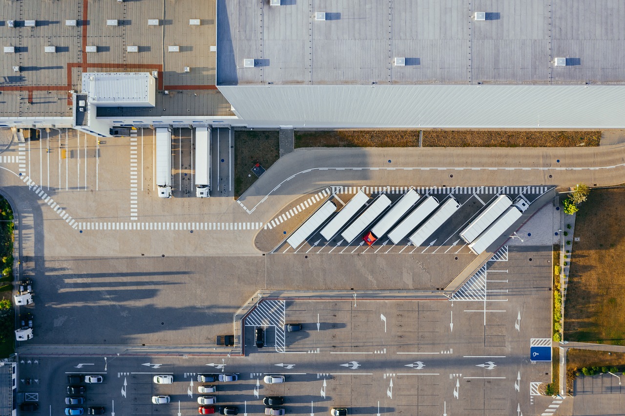 Ausfuhrbegleitdokument – Logistik und LKW-Verladung Luftaufnahme eines Logistikzentrums mit parkenden LKWs